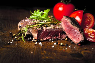 Otlar ve baharatlar ile lezzetli biftek bakış ahşap masa üzerinde kapatın