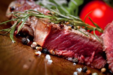 Otlar ve baharatlar ile lezzetli biftek bakış ahşap masa üzerinde kapatın