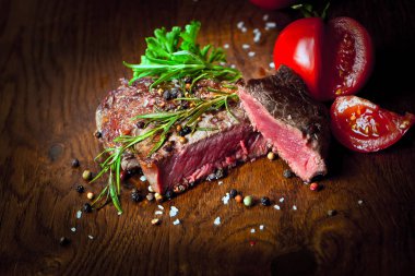 Otlar ve baharatlar ile lezzetli biftek bakış ahşap masa üzerinde kapatın