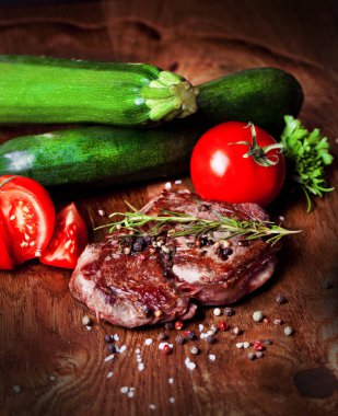 Otlar ve baharatlar ile lezzetli biftek bakış ahşap masa üzerinde kapatın