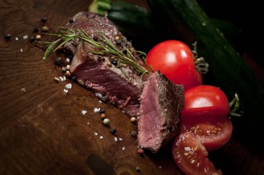 Otlar ve baharatlar ile lezzetli biftek bakış ahşap masa üzerinde kapatın