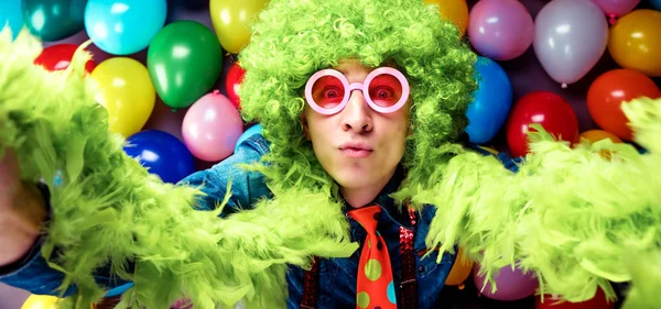 Молодой Человек Зеленом Парике Очках Позирует Фоне Разноцветного Баллона Вечеринок — стоковое фото