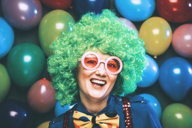 yeşil peruk ve gözlük renkli parti balon arka plan balon düzinelerce ile poz komik genç kadın