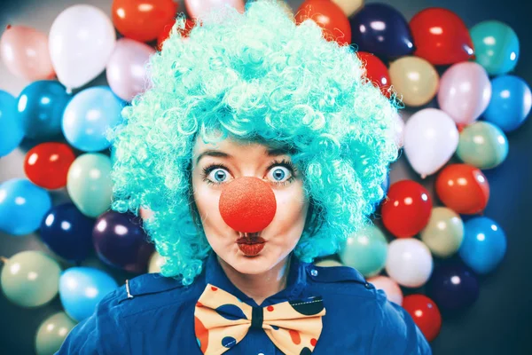 beautiful happy young woman with clown nose looking at camera and celebrating carnival or New Year in party club