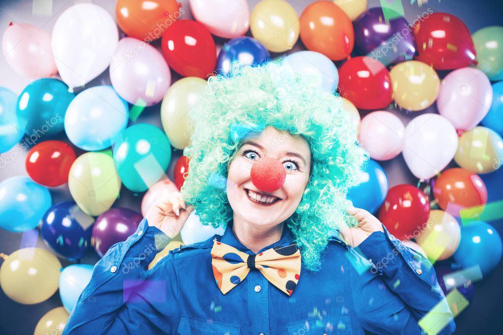 happy young woman with clown nose smiling at camera and celebrating carnival or New Year in party club 