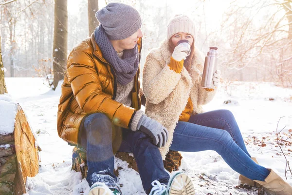 Feliz Joven Pareja Bebiendo Caliente Sentados Juntos Bosque Invierno — Foto de Stock