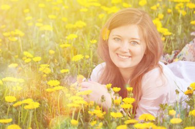 Görüntü güzel kadının mutlu neşeli kız dandelions çayır, gevşeme ilkbaharda, tatil açık dinlenme dandelions, çim üzerinde yalan