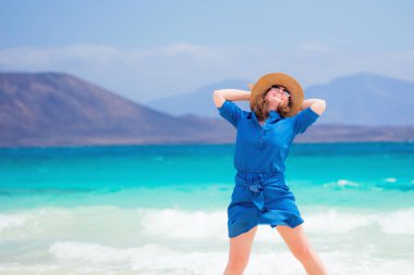 Mutlu bir kadın yolcu onu tatil tropikal plaj keyfi mavi elbiseli