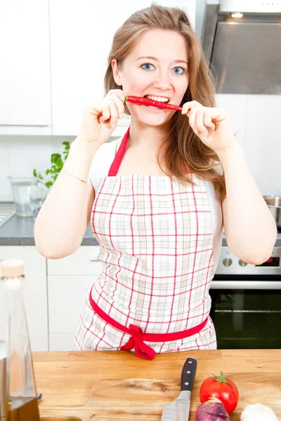 Bela Mulher Feliz Avental Mordendo Pimenta Vermelha Olhando Para Câmera — Fotografia de Stock