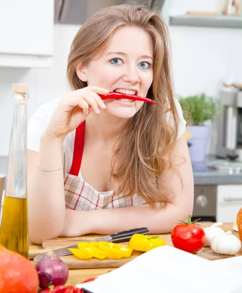 Mooie Jonge Vrouw Schort Bijten Rode Chilipeper Camera Kijken Tijdens — Stockfoto