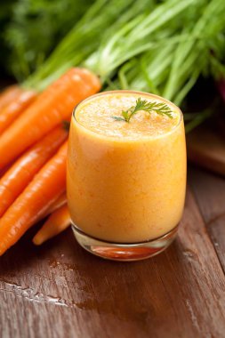 Cam ve ahşap zemin üzerine taze havuç havuç suyu. Sağlıklı gıda kavramı