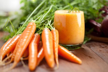 Cam ve ahşap zemin üzerine taze havuç havuç suyu. Sağlıklı gıda kavramı