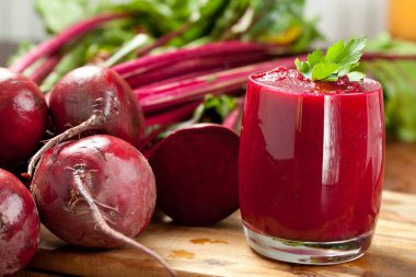 Glass of fresh beetroot juice with beets on wooden table clipart