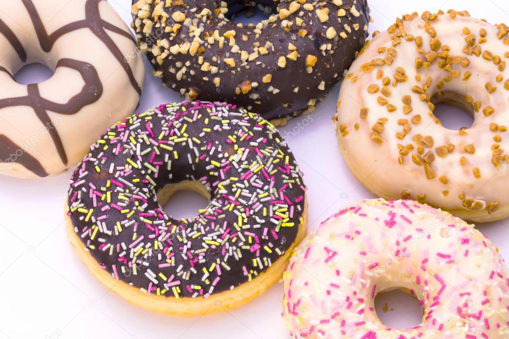 close-up view of various delicious donuts on white background