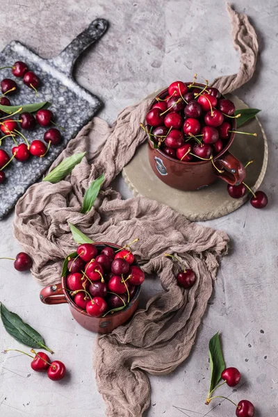 Topputsikt Över Muggar Med Färska Söta Körsbär Med Gröna Blad — Stockfoto