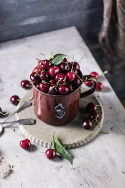 beyaz masada taze olgun kiraz ve kaşık ile fincan yakın çekim görünümü 