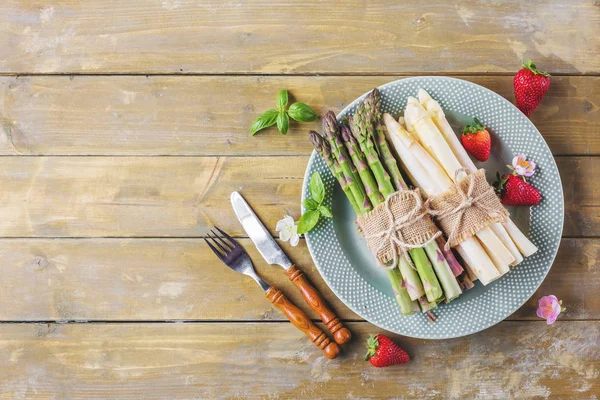 Manojos Espárragos Fresas Plato Sobre Fondo Madera — Foto de Stock