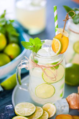 taze ev yapımı limonata ile mason kavanoz, ahşap masada pipet ve buz küpleri içme