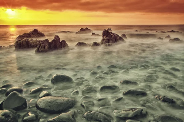 日落时美丽的海景 有石头在水中 天空多云 — 图库照片