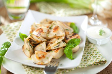 lezzetli köfte et, fesleğen yaprakları ve beyaz tabakta ekşi krema ile dolu görmek