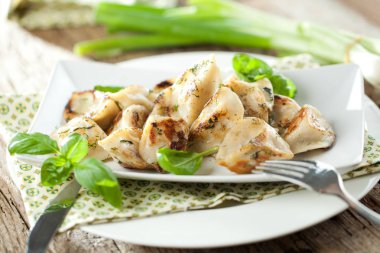 lezzetli köfte et, fesleğen yaprakları ve beyaz tabakta ekşi krema ile dolu görmek