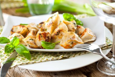 lezzetli köfte et, fesleğen yaprakları ve beyaz tabakta ekşi krema ile dolu görmek