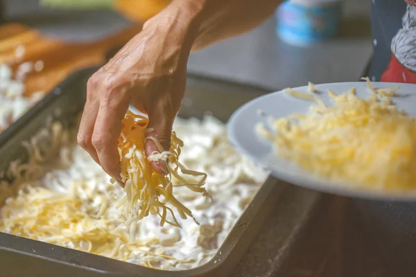 Обрезанный Снимок Человека Добавляющего Тертый Сыр Вкусному Мясу Поднос Выпечки — стоковое фото