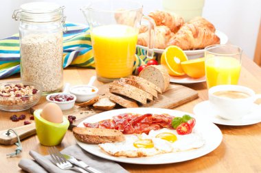 lezzetli kahvaltı ile kızarmış yumurta ve domuz pastırması, dilimlenmiş ekmek, haşlanmış yumurta, ahşap masa kahve ve portakal suyu fincan