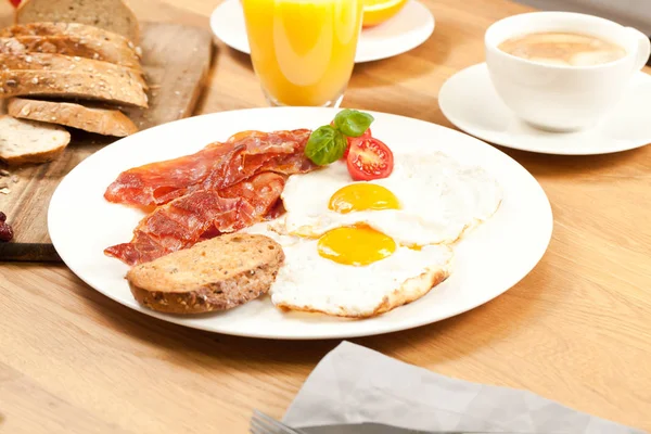 Σερβίρεται Γευστικό Πρωινό Τηγανητά Αυγά Και Μπέικον Ψωμί Χυμό Πορτοκάλι — Φωτογραφία Αρχείου