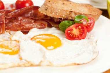 Sahanda yumurta ve domuz pastırması, ekmek ve kiraz domates ile lezzetli breakfast yakından görmek