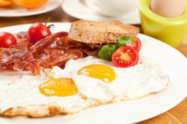 Sahanda yumurta ve domuz pastırması, ekmek ve kiraz domates ile lezzetli breakfast yakından görmek
