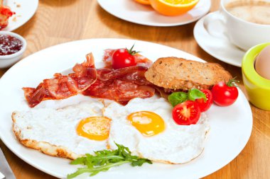 Sahanda yumurta ve domuz pastırması, ekmek ve kiraz domates ile lezzetli breakfast yakından görmek