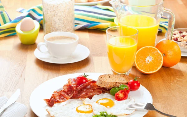 Leckeres Frühstück Mit Spiegeleiern Und Speck Kirschtomaten Orangensaft Kaffee Gekochtem — Stockfoto