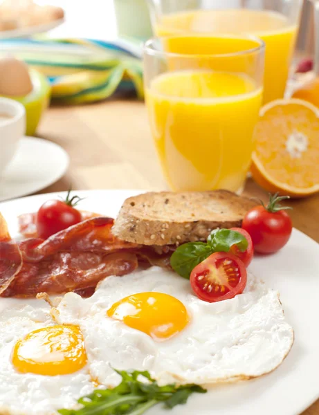 Närbild Välsmakande Frukost Med Stekt Ägg Och Bacon Cocktailtomater Apelsiner — Stockfoto