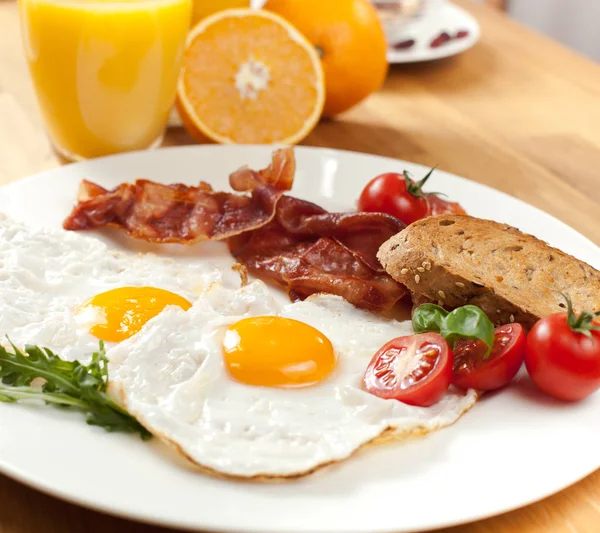 Närbild Välsmakande Frukost Med Stekt Ägg Och Bacon Cocktailtomater Apelsiner — Stockfoto