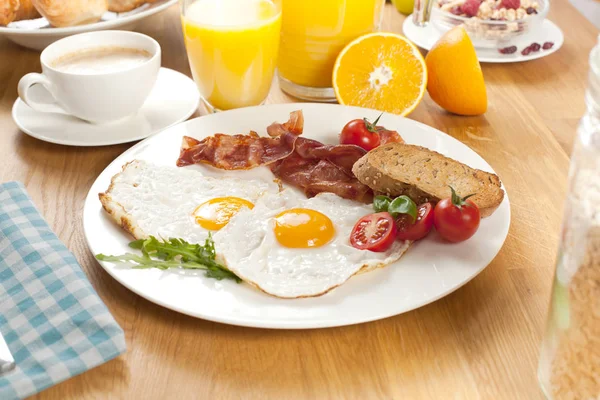 Leckeres Frühstück Mit Spiegeleiern Und Speck Brot Kirschtomaten Orangensaft Und — Stockfoto