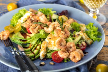 gurme karides salata avokado dilimleri ve sağlıklı sebze yakın çekim görünümünü mavi plaka üzerinde