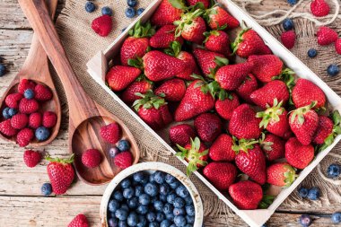 ahşap masa üzerinde taze sağlıklı böğürtlen, ahududu ve çilek üstten görünüm