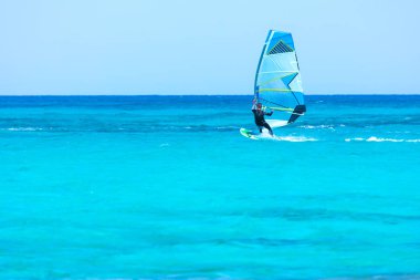 Kiteboardcu uçurtma atleti uçurtma sörfü numaraları yapıyor.