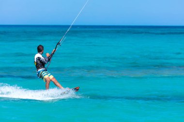 Kiteboardcu uçurtma atleti uçurtma sörfü numaraları yapıyor.