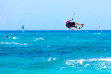 Kiteboardcu uçurtma atleti uçurtma sörfü numaraları yapıyor.