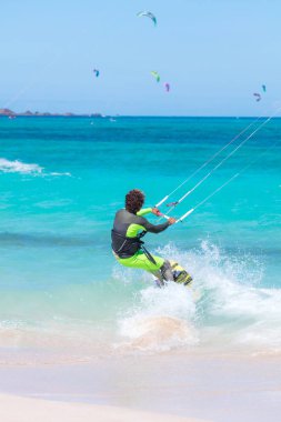 Kiteboardcu uçurtma atleti uçurtma sörfü numaraları yapıyor.