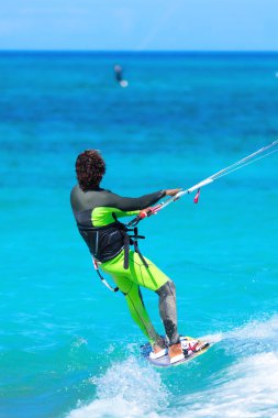 Kiteboardcu uçurtma atleti uçurtma sörfü numaraları yapıyor.