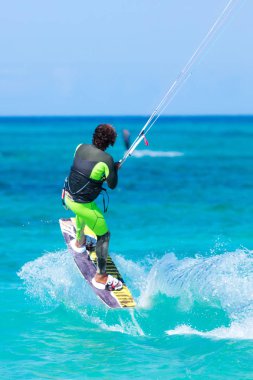 Kiteboardcu uçurtma atleti uçurtma sörfü numaraları yapıyor.