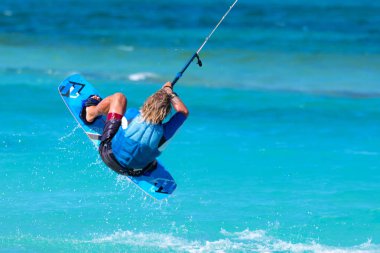Kiteboardcu uçurtma atleti uçurtma sörfü numaraları yapıyor.