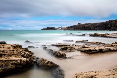 Güzel kumlu sahil ve yaz zamanı bulutlu gökyüzü