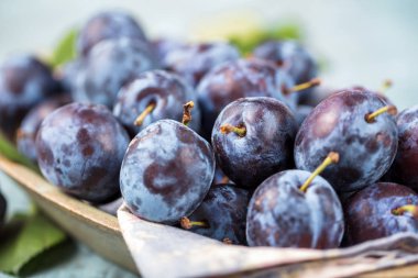 Taze yaprak yeşil rustik tablo hasır sepet ve hlaf erik erik yığını.