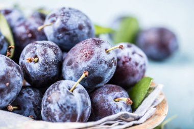 Taze yaprak yeşil rustik tablo hasır sepet ve hlaf erik erik yığını.