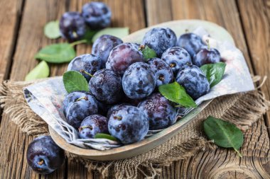 Taze yaprak yeşil rustik tablo hasır sepet ve hlaf erik erik yığını.