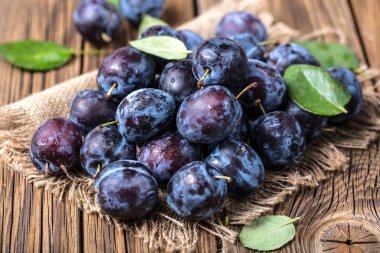 Taze yaprak yeşil rustik tablo hasır sepet ve hlaf erik erik yığını.